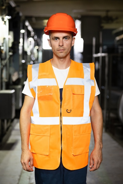 Foto retrato de alegre capataz constructor en casco de seguridad con el rostro cubierto de suciedad, mirar a la cámara