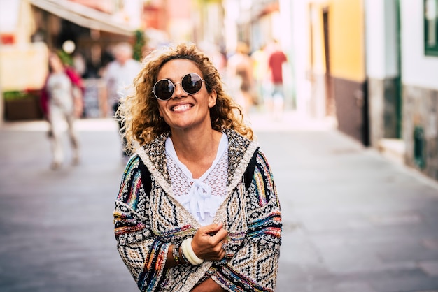 Retrato alegre da moda linda senhora caucasiana sorrindo e andando no outdor da cidade com uma jaqueta de primavera da moda
