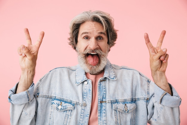 Retrato de un alegre hombre de mediana edad vestido con traje casual que se encuentran aisladas, mostrando gesto de paz