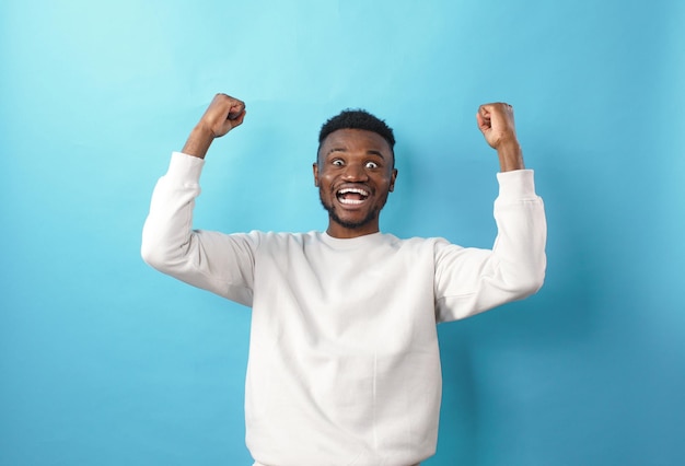 Retrato de un alegre joven afroamericano feliz gritando con las manos levantadas en un cartel