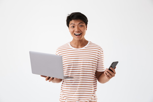 Retrato de un alegre joven asiático con portátil