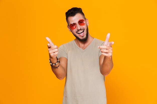 Retrato de un alegre joven casual en gafas de sol