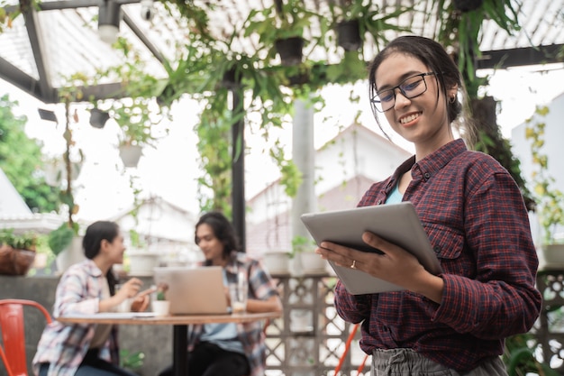 Retrato de alegre de jóvenes estudiantes asiáticos reunidos en un café