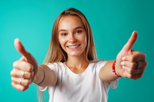 Retrato, de, un, alegre, mujer joven, actuación, pulgares arriba, señal