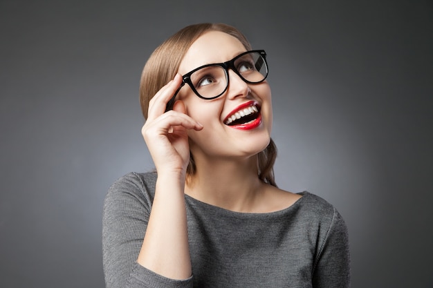 Retrato, de, alegre, mujer joven, en, anteojos, mirar hacia arriba