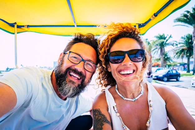 Retrato de alegre pareja caucásica disfrutando de las vacaciones durante el viaje por carretera. Feliz pareja riendo durante su viaje. Pareja alegre tomando selfie de vacaciones