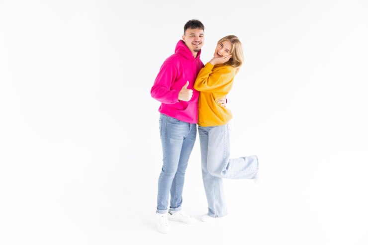 retrato, de, un, alegre, pareja joven, llevando, hoodies, posición, aislado, encima, blanco, plano de fondo, ok, gesto