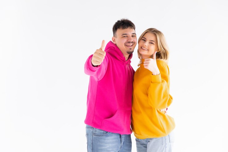 retrato, de, un, alegre, pareja joven, llevando, hoodies, posición, aislado, encima, blanco, plano de fondo, ok, gesto
