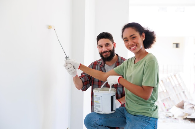 Retrato Alegre pareja joven y mujer negra sonriendo durante la renovación en un nuevo apartamento