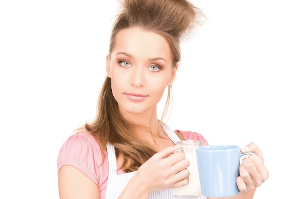 Retrato de ama de casa hermosa con leche y taza