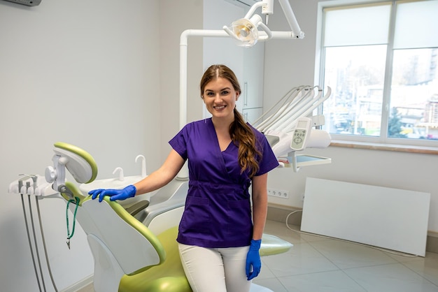 Retrato de una amigable dentista feliz en uniforme y paciente en espera en la clínica moderna de atención médica