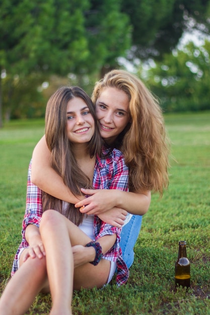 Retrato de amigas abrazándose en el campo en el parque