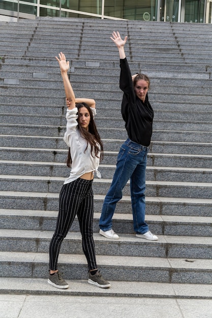 Foto retrato de amigas de pie en los escalones