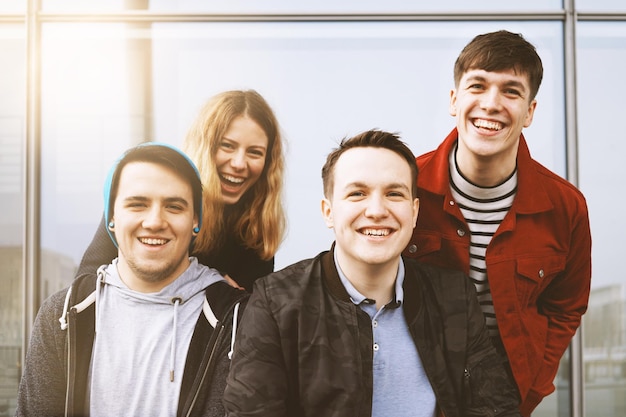 Foto retrato de amigos alegres de pie junto a la ventana