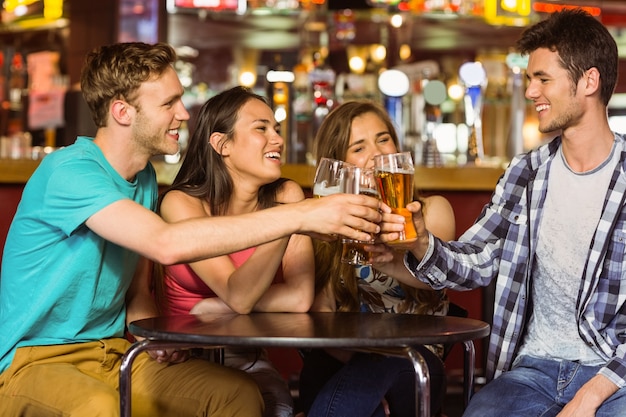 Foto retrato de amigos felices brindando con bebida y cerveza