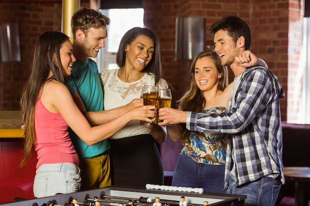 Foto retrato de amigos felices brindando con cerveza y bebida mixta