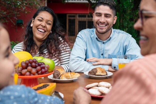 Foto retrato de amigos sonrientes comiendo en casa