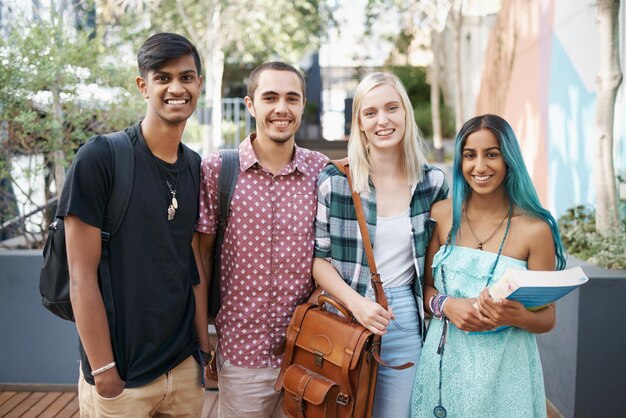 Foto retrato de amigos sonrientes de pie contra los árboles