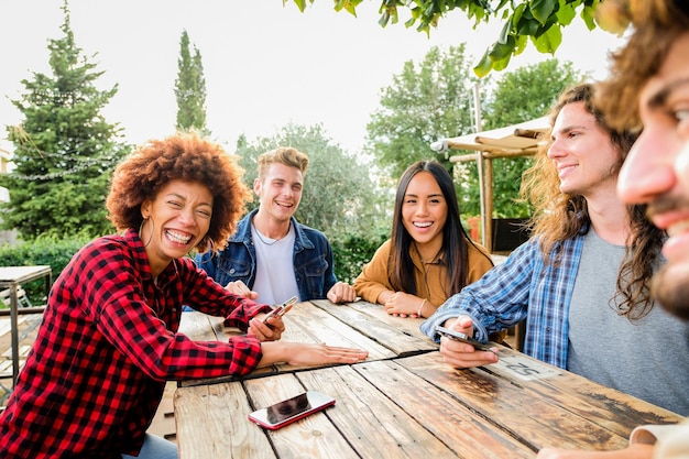 Retrato de amigos sonrientes de pie contra los árboles