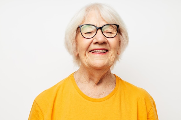 Retrato de una anciana amigable con camiseta casual y anteojos de fondo aislado