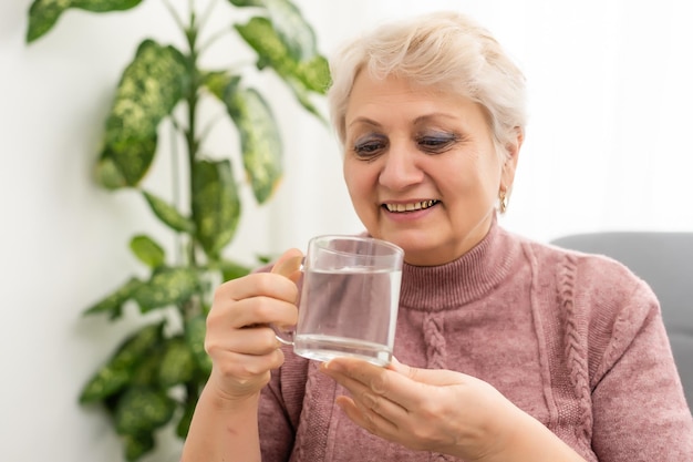 Retrato de una anciana bebiendo un vaso de agua.
