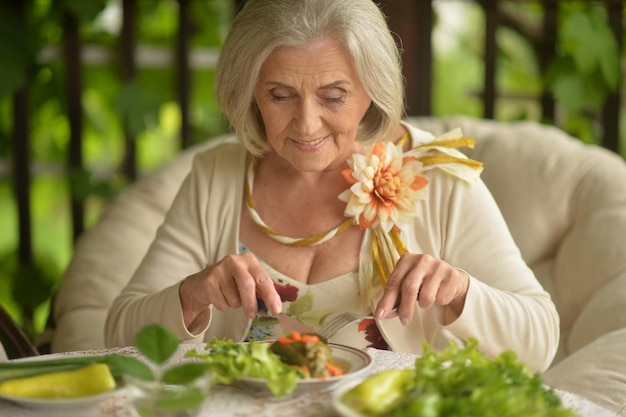 Retrato de una anciana feliz comiendo una deliciosa ensalada