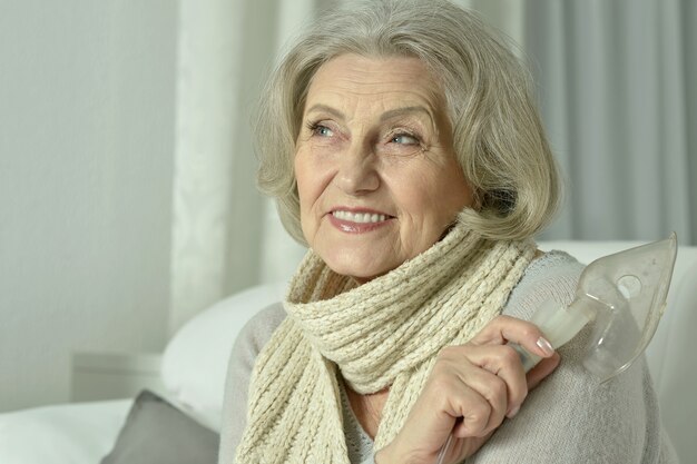 Retrato de anciana con inhalación de gripe