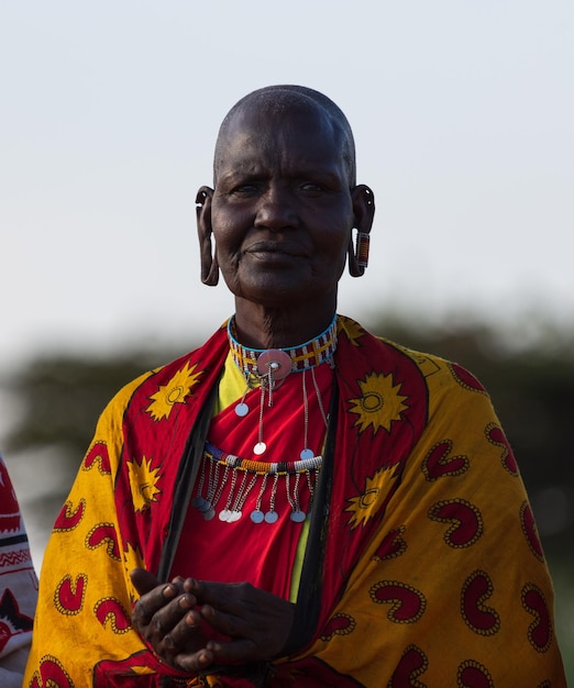 Un retrato de una anciana masai vestida con ropa tradicional y con agujeros en las orejas. Masai Mara, Kenia