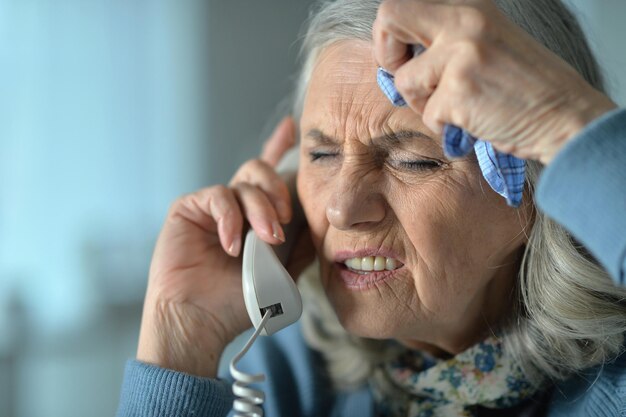 Retrato de una anciana molesta llamando al médico