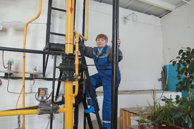 Retrato de anciana en overoles de trabajo en el sitio de fabricación