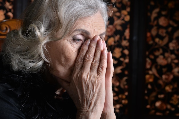 Retrato de una anciana triste en casa