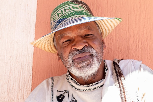 Retrato de un anciano afroamericano de pelo gris con un sombrero con su nombre