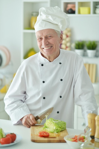 Retrato de anciano chef masculino cocinando en la cocina