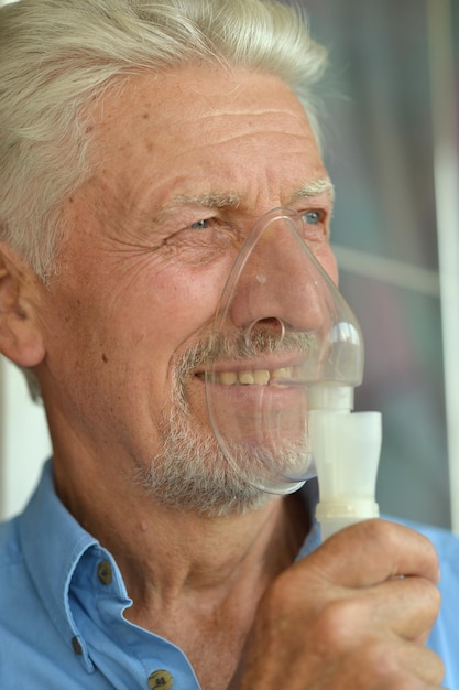 Retrato de un anciano enfermo con inhalador