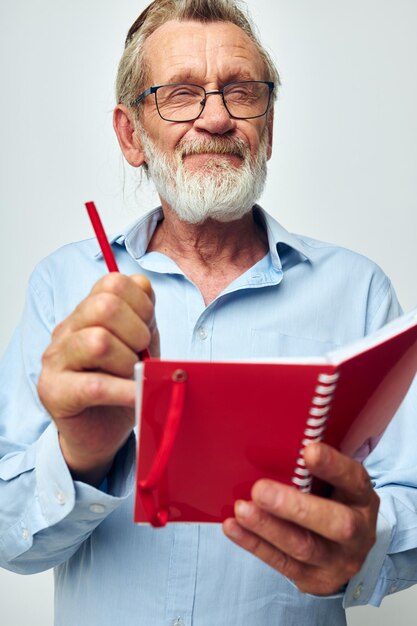 Retrato anciano escribe emociones en un cuaderno de fondo claro