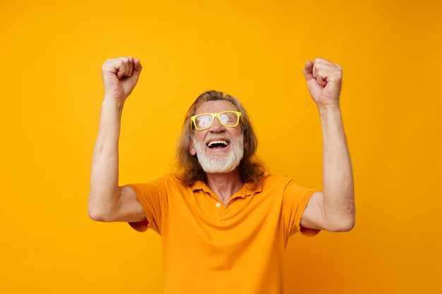 Retrato de un anciano feliz con gafas amarillas con una barba gris emociones vista recortada