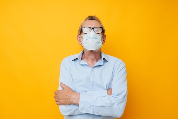 Retrato de un anciano feliz con gafas máscara médica de seguridad posando vista recortada