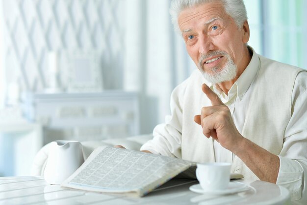 Retrato de un anciano feliz leyendo el periódico