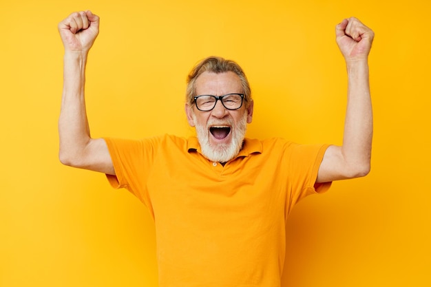 Retrato anciano con gafas camiseta amarilla posando disparo monocromo