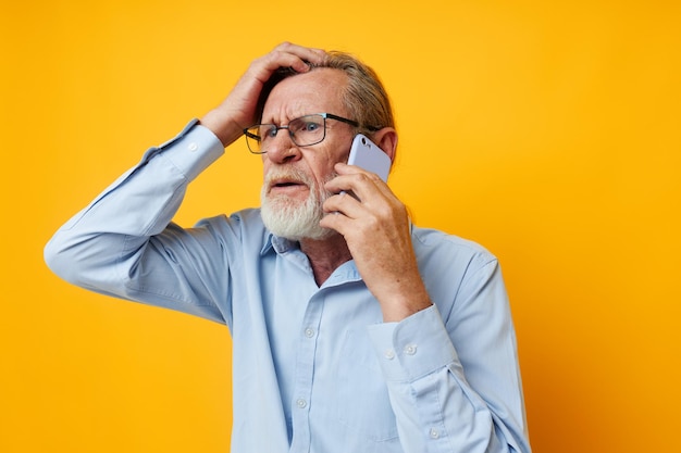 Retrato anciano hablando por teléfono posando closeup fondo aislado