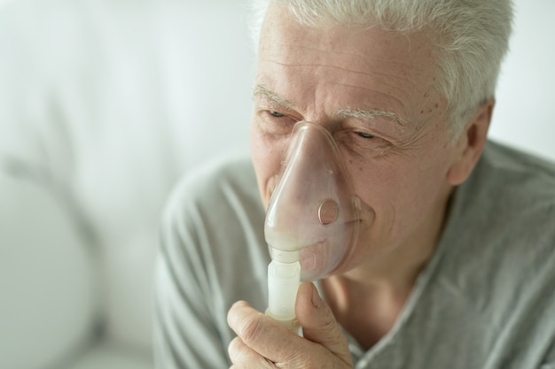 Retrato de anciano con inhalación de gripe