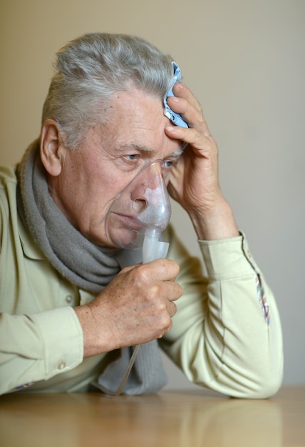 Retrato de anciano con inhalación de gripe