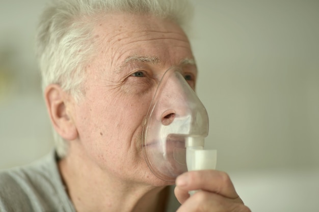 Retrato de anciano con inhalación de gripe