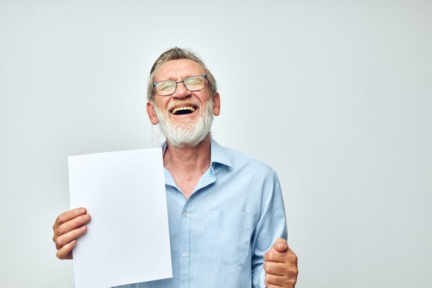 Retrato anciano sosteniendo una hoja de papel copyspace posando vista recortada