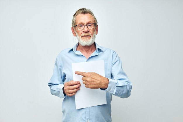 Retrato anciano sosteniendo una hoja de papel copyspace posando vista recortada