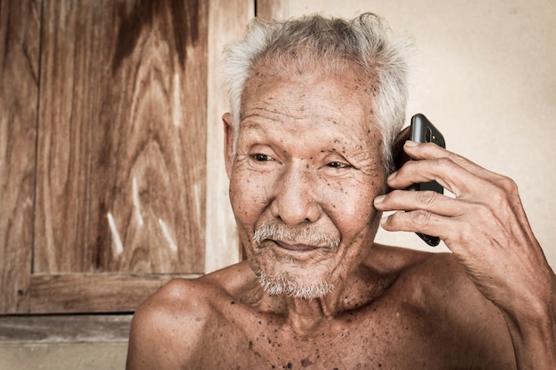 Retrato de anciano uso teléfono, tono vintage