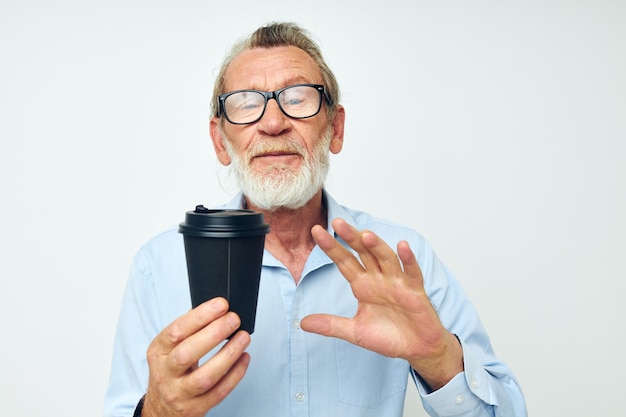 Retrato anciano con un vaso negro en sus manos una bebida fondo aislado