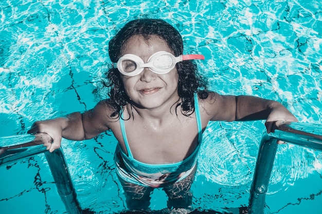 Retrato en ángulo alto de una chica en una piscina