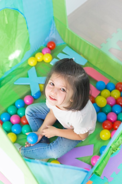 Retrato en ángulo alto de una niña sentada en una tienda de campaña