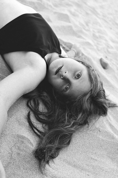 Retrato en ángulo alto de una niña tendida en la arena